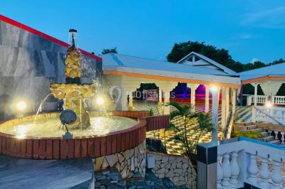 Un couple de mariés danse au centre d'une salle décorée, entouré d'invités applaudissant.