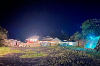 Un couple de mariés danse au centre d'une salle décorée, entouré d'invités applaudissant.