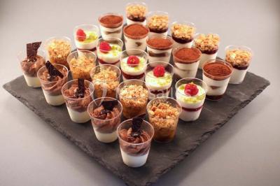 Allée décorée pour une cérémonie en plein air, entourée d'arbres, avec chaises en bois et rubans suspendus.