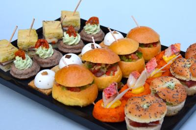 Allée décorée pour une cérémonie en plein air, entourée d'arbres, avec chaises en bois et rubans suspendus.