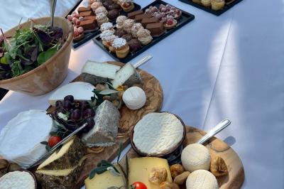 Allée décorée pour une cérémonie en plein air, entourée d'arbres, avec chaises en bois et rubans suspendus.