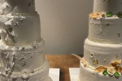 Allée décorée pour une cérémonie en plein air, entourée d'arbres, avec chaises en bois et rubans suspendus.