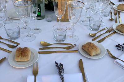 Allée décorée pour une cérémonie en plein air, entourée d'arbres, avec chaises en bois et rubans suspendus.