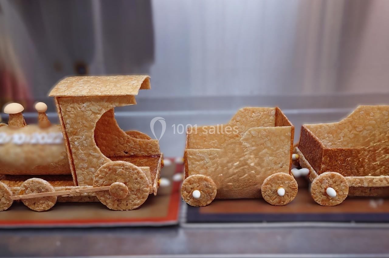 Train miniature en pâte croustillante avec deux wagons, posé sur une surface de cuisine.