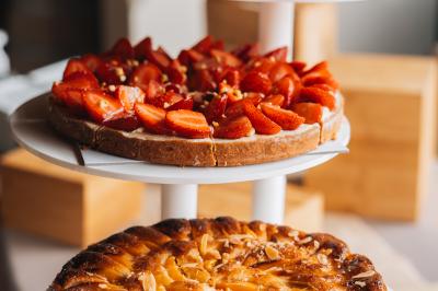 Personne utilisant une trancheuse rouge pour couper de la charcuterie dans un environnement professionnel.