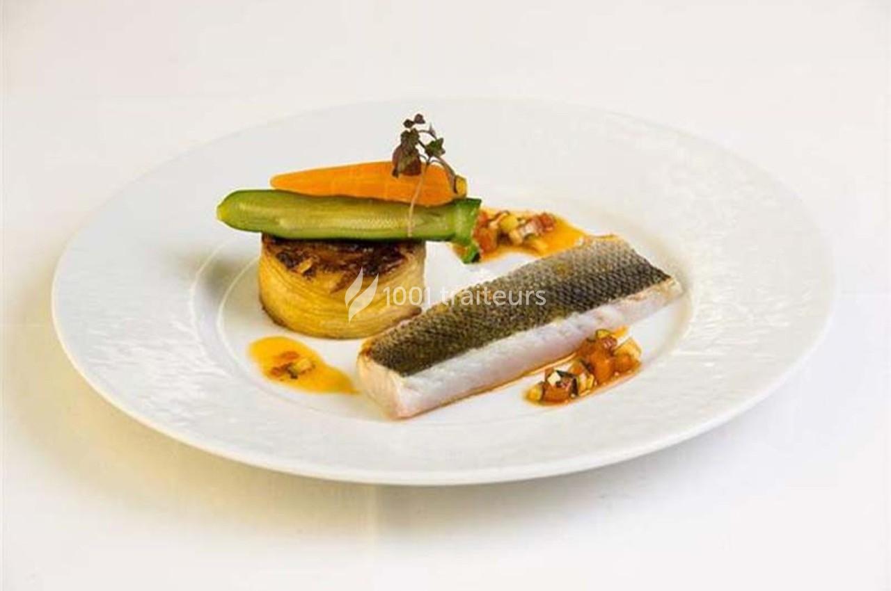 Assiette gastronomique avec filet de poisson, légumes colorés, millefeuille de pommes de terre et sauce décorative.
