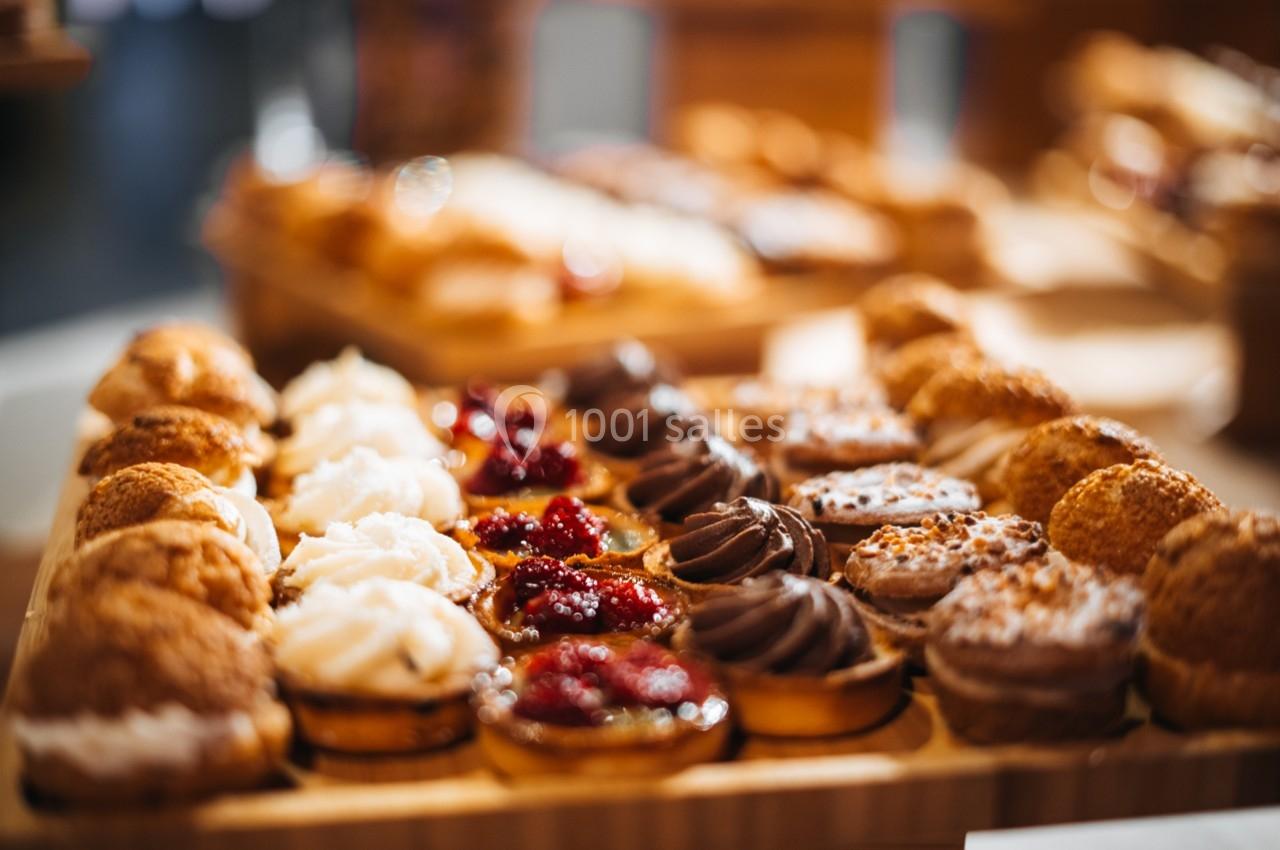 Plateau de pâtisseries variées comprenant des choux, des tartes aux fruits rouges et des desserts au chocolat.