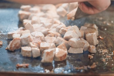 Portion de viande braisée servie dans une petite coupelle, garnie de pousses rouges.
