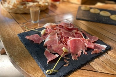 Portion de viande braisée servie dans une petite coupelle, garnie de pousses rouges.