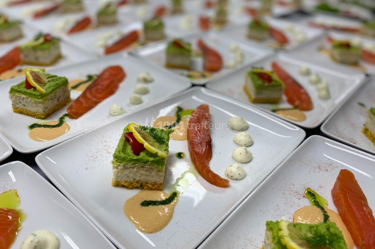 Assiettes dressées avec des tranches de saumon fumé, mousses colorées, sauces et décorations raffinées.
