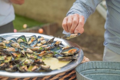 Portion de viande braisée servie dans une petite coupelle, garnie de pousses rouges.