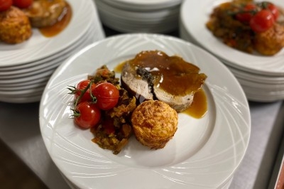 Plat gastronomique composé d'une mousse verte, surmontée de saumon et de pousses, présenté dans une assiette blanche.