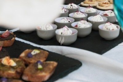 Plat gastronomique composé d'une mousse verte, surmontée de saumon et de pousses, présenté dans une assiette blanche.