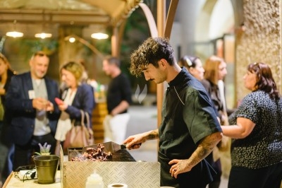 Plat gastronomique composé d'une mousse verte, surmontée de saumon et de pousses, présenté dans une assiette blanche.