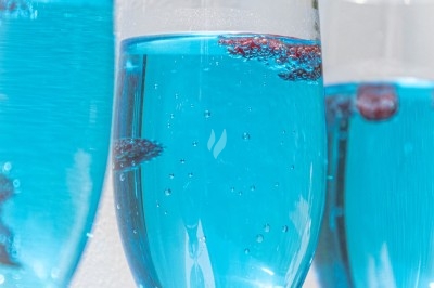 Plat gastronomique composé d'une mousse verte, surmontée de saumon et de pousses, présenté dans une assiette blanche.