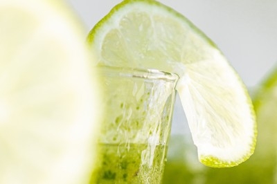Plat gastronomique composé d'une mousse verte, surmontée de saumon et de pousses, présenté dans une assiette blanche.