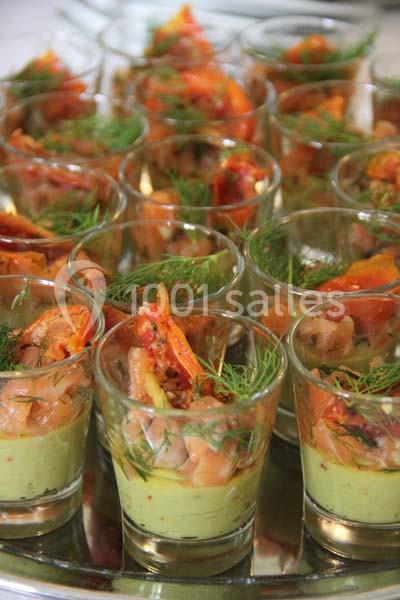 Verrines garnies de mousse d'avocat, saumon fumé, tomates séchées et brins d'aneth, présentées sur un plateau.