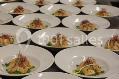 Miniature Traiteur Garancières (Yvelines) - Havane Traiteur #9 Table dressée avec nappes blanches, couverts, menus et bouquets de fleurs, entourée de chaises en bois dans une salle.