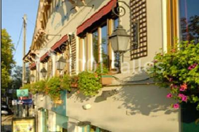 Miniature Traiteur Garancières (Yvelines) - Havane Traiteur #21 Table dressée avec nappes blanches, couverts, menus et bouquets de fleurs, entourée de chaises en bois dans une salle.