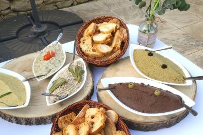 Un serveur remplit un verre de boisson pour un homme lors d'un buffet avec des verrines et des invités en arrière-plan.