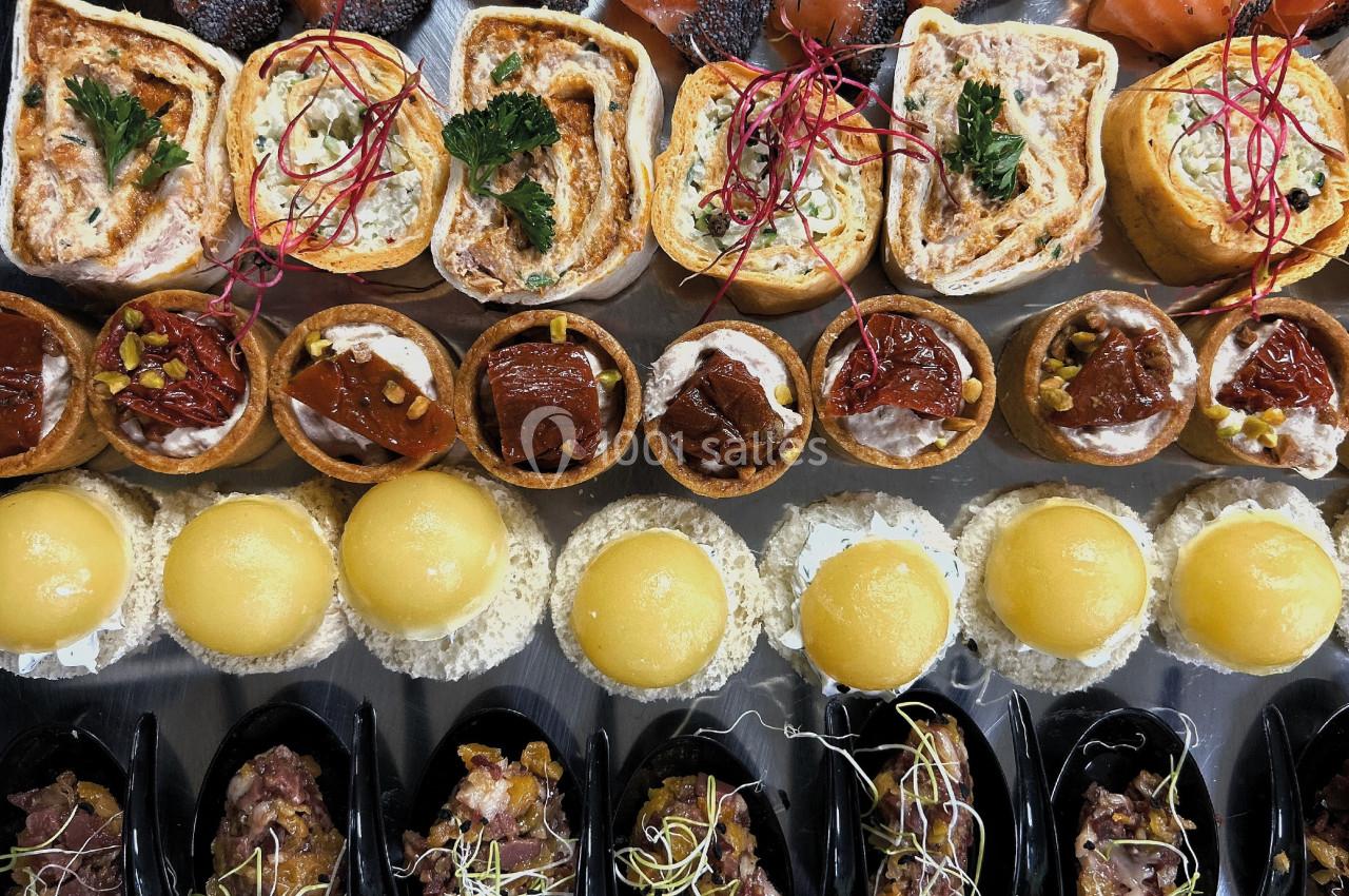 Plateau de bouchées apéritives variées comprenant roulés, tartelettes, mini pains garnis, moules et saumon fumé.