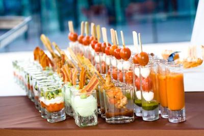 Miniature Traiteur Chaponost (Rhône) - Jacques Lafargue Traiteur #13 Une main coupe un rouleau de foie gras sur une planche en bois, entouré de figues et de tomates cerises.