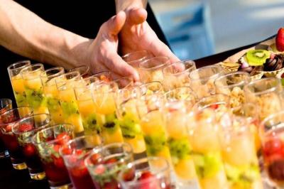 Miniature Traiteur Chaponost (Rhône) - Jacques Lafargue Traiteur #3 Une main coupe un rouleau de foie gras sur une planche en bois, entouré de figues et de tomates cerises.