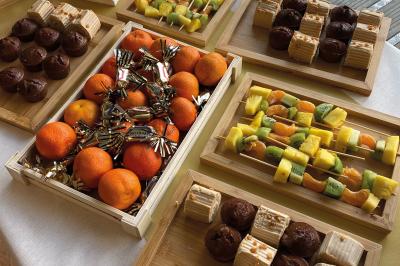 Miniature Traiteur Chaponost (Rhône) - Jacques Lafargue Traiteur #14 Une main coupe un rouleau de foie gras sur une planche en bois, entouré de figues et de tomates cerises.