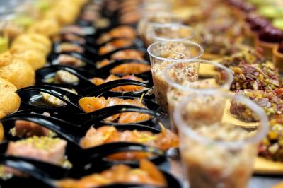 Miniature Traiteur Chaponost (Rhône) - Jacques Lafargue Traiteur #28 Une main coupe un rouleau de foie gras sur une planche en bois, entouré de figues et de tomates cerises.