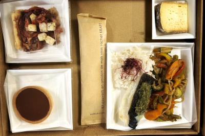 Miniature Traiteur Chaponost (Rhône) - Jacques Lafargue Traiteur #30 Une main coupe un rouleau de foie gras sur une planche en bois, entouré de figues et de tomates cerises.