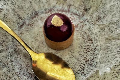 Miniature Traiteur Chaponost (Rhône) - Jacques Lafargue Traiteur #31 Une main coupe un rouleau de foie gras sur une planche en bois, entouré de figues et de tomates cerises.