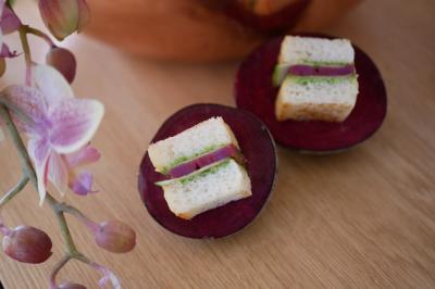 Miniature Traiteur Neuilly-sur-Seine (Hauts-de-Seine) - Arômes et Sens #3 Assortiment de mini-pâtisseries variées sur une assiette noire, disposées sur une table en bois.