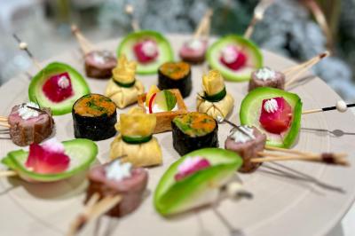 Miniature Traiteur Neuilly-sur-Seine (Hauts-de-Seine) - Arômes et Sens #5 Assortiment de mini-pâtisseries variées sur une assiette noire, disposées sur une table en bois.