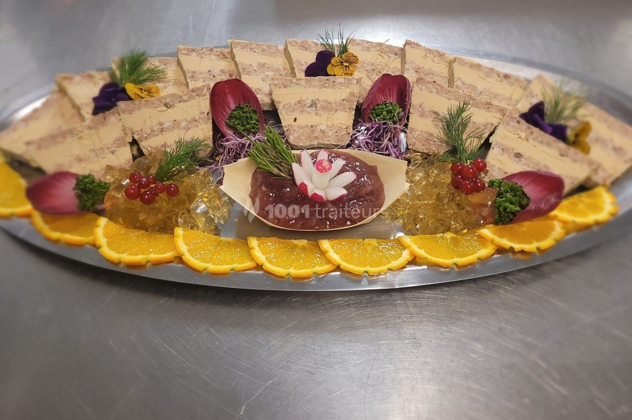 Plateau de terrines décorées avec gelée, tranches d'orange, groseilles et garnitures florales sur un plat argenté.