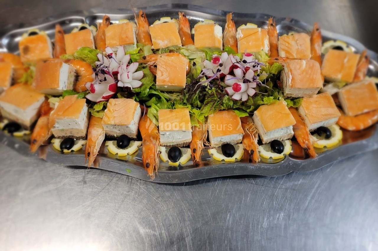 Plateau de saumon fumé, crevettes, olives noires et garniture de salade verte, présenté sur un plat argenté.