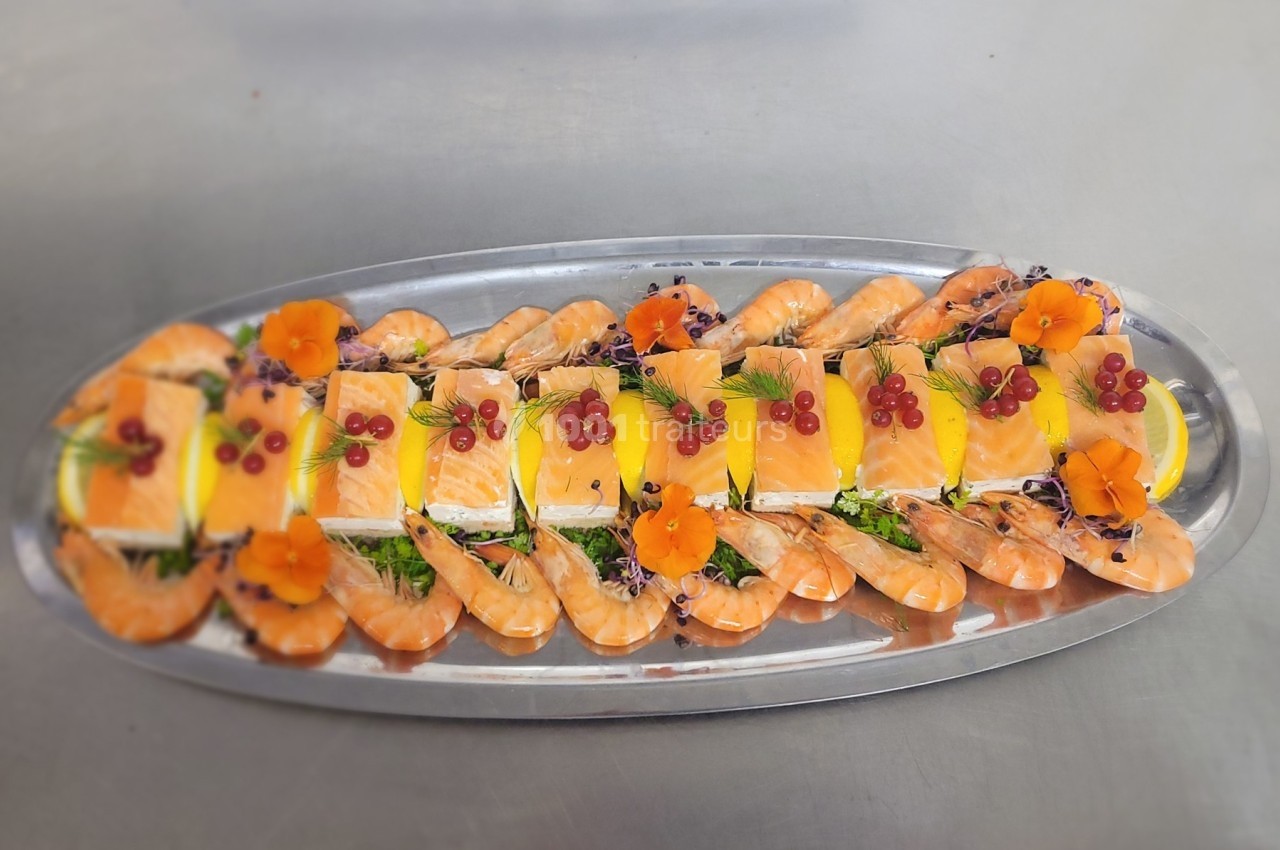 Plateau de fruits de mer avec crevettes, tranches de saumon, citron, herbes fraîches et décorations florales.