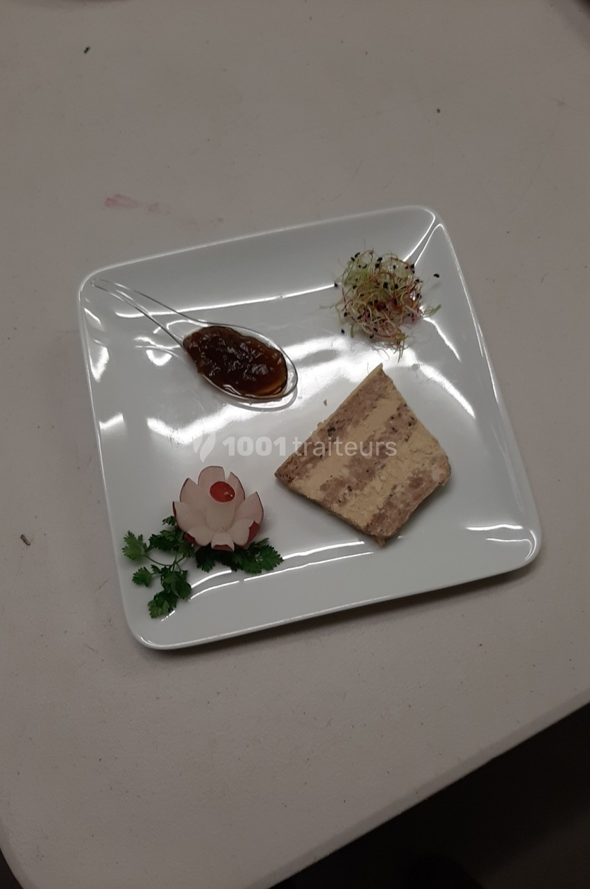 Assiette contenant une tranche de terrine, une garniture de radis sculpté, des pousses et une sauce brune.