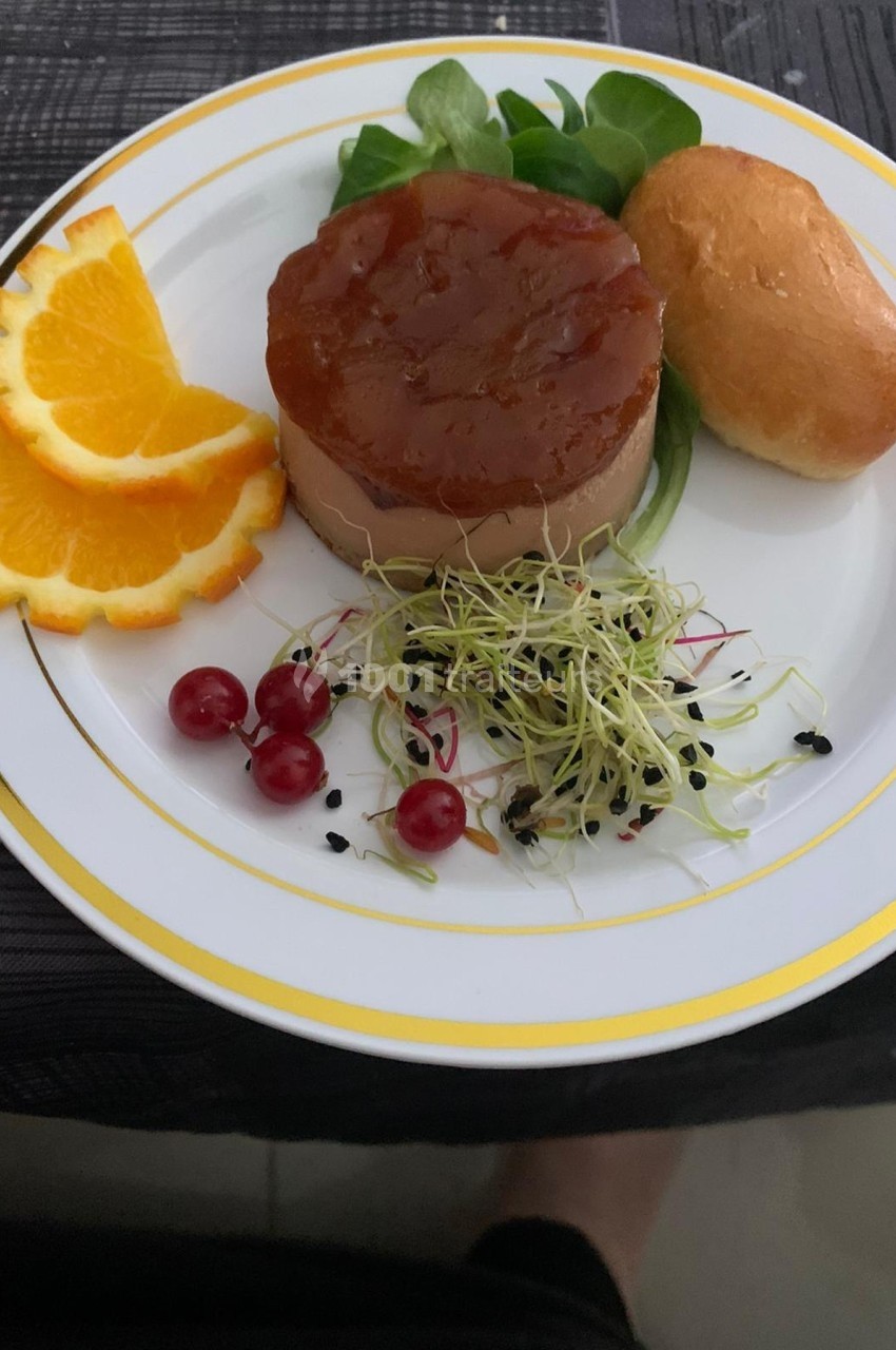 Assiette composée de foie gras, gelée, pain brioché, tranches d'orange, groseilles, jeunes pousses et graines noires.