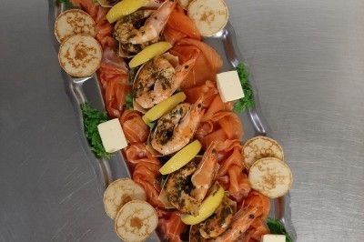 Assiette composée de foie gras, gelée, pain brioché, tranches d'orange, groseilles, jeunes pousses et graines noires.