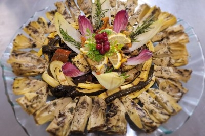 Assiette composée de foie gras, gelée, pain brioché, tranches d'orange, groseilles, jeunes pousses et graines noires.