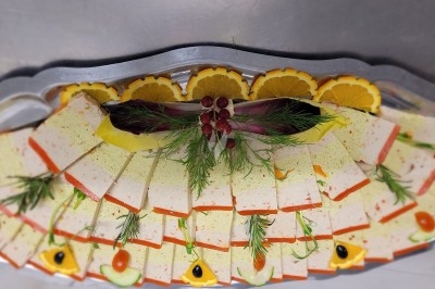 Assiette composée de foie gras, gelée, pain brioché, tranches d'orange, groseilles, jeunes pousses et graines noires.