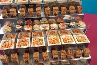 Assiette composée de foie gras, gelée, pain brioché, tranches d'orange, groseilles, jeunes pousses et graines noires.