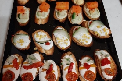 Assiette composée de foie gras, gelée, pain brioché, tranches d'orange, groseilles, jeunes pousses et graines noires.