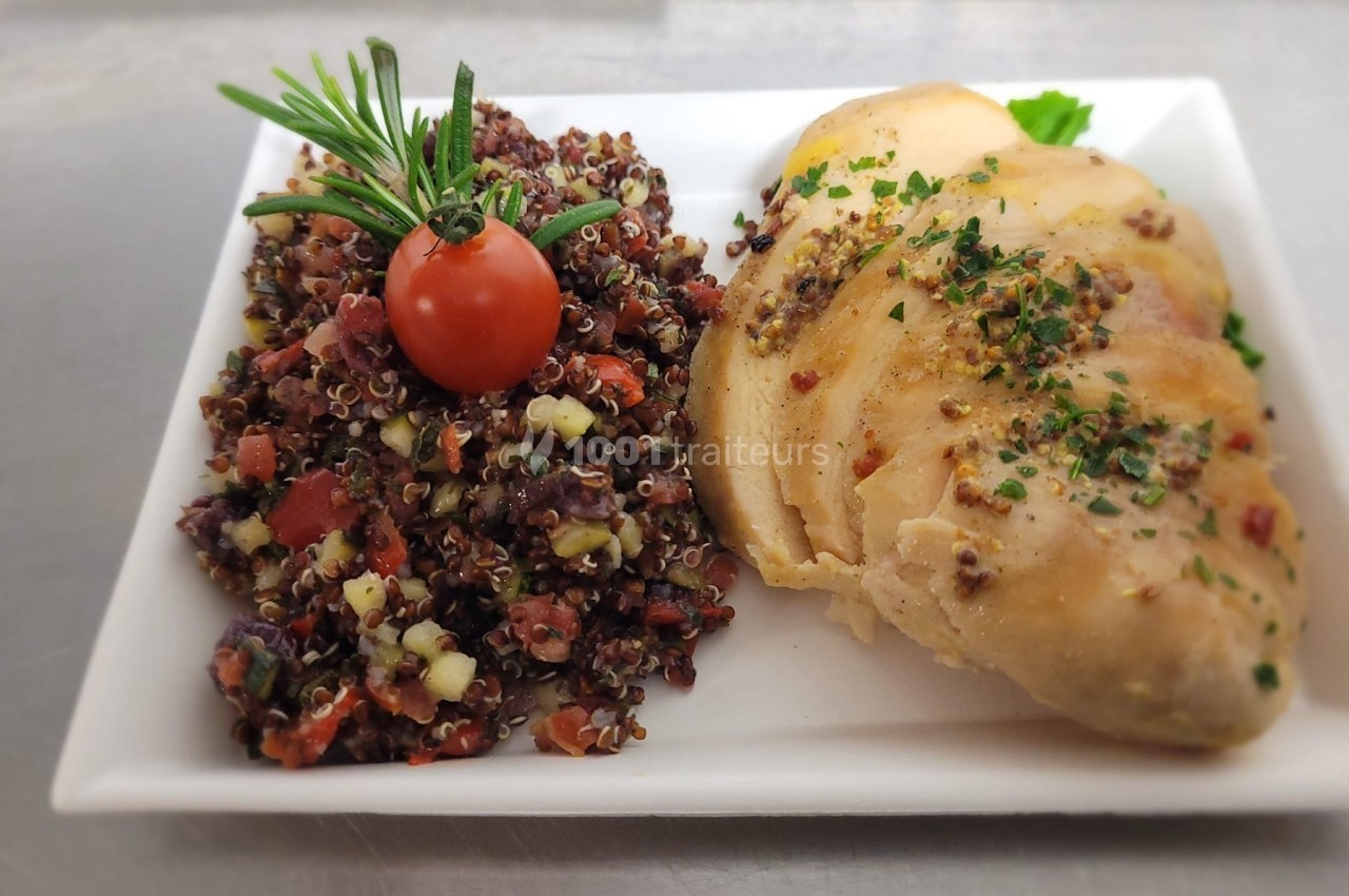 Assiette avec filet de poulet tranché et salade de quinoa garnie de tomate cerise et brin de romarin.