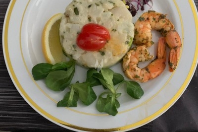 Assiette composée de foie gras, gelée, pain brioché, tranches d'orange, groseilles, jeunes pousses et graines noires.