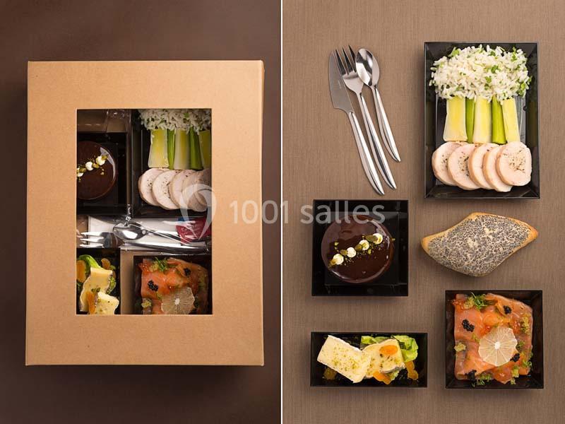 Plateau repas gastronomique avec saumon fumé, volaille, riz, fromage, dessert au chocolat et pain aux graines.