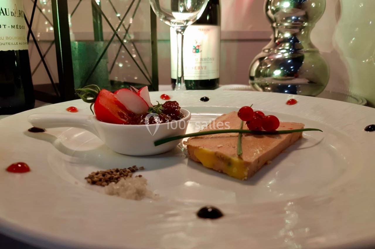 Assiette de foie gras avec gelée, radis, groseilles et condiments, présentée dans un cadre raffiné.