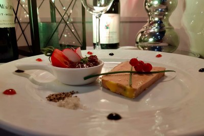Salle de réception éclairée en bleu avec des tables rondes dressées et des écrans disposés autour.