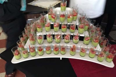Table décorée pour un dîner, avec nappes blanches, serviettes pliées, lanternes, fleurs et couverts disposés.