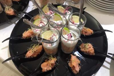 Table décorée pour un dîner, avec nappes blanches, serviettes pliées, lanternes, fleurs et couverts disposés.
